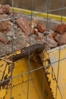 Yıkım tuğlaları konteynırda. Çöplerle dolu bir konteynır. İnşaat alanı. Bina yeniden inşa ediliyor. Tuğla, orman, metal, toz gibi çöpler.