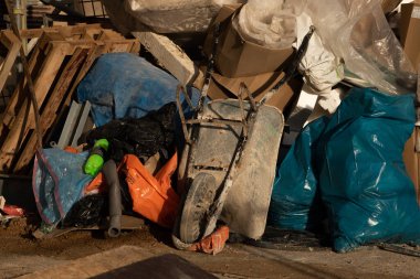 Yıkımdan kalan çöpler. El arabası ve çöp kutusu. İnşaat alanı. Bina yeniden inşa ediliyor. Tuğla, orman, metal, toz gibi çöpler.