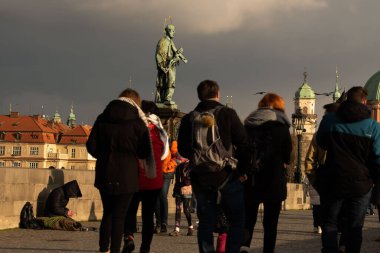 Prag, Çek Cumhuriyeti. 01-09-2021. Dilenci, Prag 'da kışın gün batımında Charles Köprüsü' nde para istiyor..