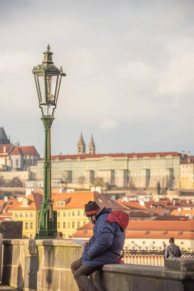 Praga Republika Czeska 2021 Człowiek Masce Czyta Moście Karola Zachodzie — Zdjęcie stockowe