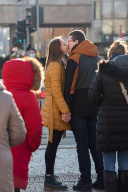 Prag, Çek Cumhuriyeti. 01-21-2021. Çiftler Prag 'ın göbeğinde güneşli bir kış sabahı, meyve ve sebze pazarına yakın yerlerde öpüşürler..