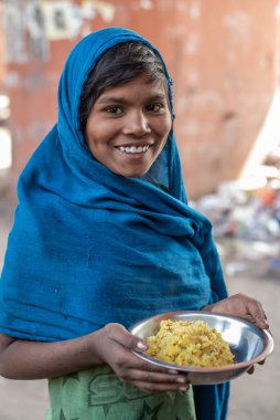 Rajasthan. Hindistan. 07-02-2018. Fakir bir mahallede sokakta yaşayan gülümseyen kadına bedava yemek verildi..