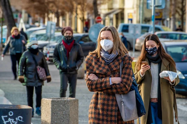 Prag, Çek Cumhuriyeti. 01-29-2021. Güneşli ve soğuk bir kış sabahı Prag 'ın merkezinde yürüyen maskeli iki genç kadının portresi..