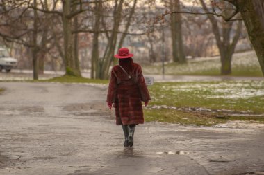 Prag, Çek Cumhuriyeti. 01-31-2021. Prag 'da soğuk kış gününde, kar üzerinde yürüyen yaşlı kadın Letna.