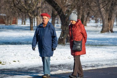 rague, Çek Cumhuriyeti. 01-31-2021. Prag 'da soğuk kış gününde kar üzerinde yürüyen ve konuşan iki kadın.