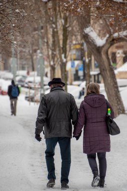 Prag, Çek Cumhuriyeti. 02-08-2021. Soğuk bir kış günü Prag şehir merkezinde el ele tutuşan yaşlı çift..