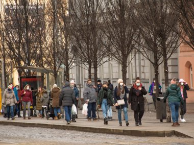 Brno, Çek Cumhuriyeti. 02-17-2021. Korona virüsünden korunmak için maske takan insanlar soğuk kış günlerinde Brno şehrinde Cheska tramvayında yürürler..