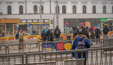 Brno, Çek Cumhuriyeti. 02-17-2021. Korona virüsünden korumak için maske takan insanlar soğuk kış günü Brno şehrindeki Halvni Nadrazi ana tramvay istasyonunda yürürler..