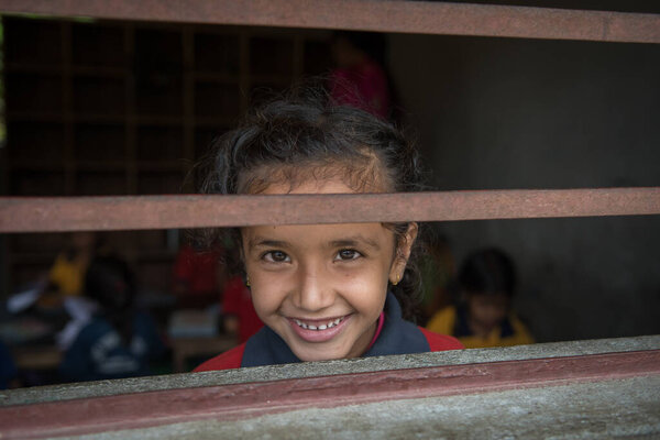 Похара, Непал. 09-15-2017. Портрет девочки из деревни в горах Непала, смеющейся во время занятий в школе.