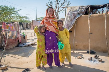 Rajasthan. Hindistan. 07-02-2018. Günbatımında Hindistan 'da küçük bir köyde iki kızı olan bir anne..