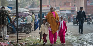 Jaipur, Hindistan. 09-05-2018. Rajasthan 'da Jaipur sokaklarında yürüyen iki çocuklu bir anne yerel marketten meyve ve sebze alırken....