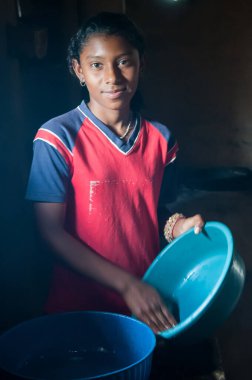 Rivas, Nicaragua. 07-15-2016. Girl is cleaning dishes as part of her regular duties living with her family in Rivas, a rural area of Nicaragua. clipart