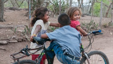 Rivas, Nikaragua. 07-15-2016. Çocuklar bisiklet sürerken eğleniyorlar. Ülkenin kırsal kesimlerinde yaşayan insanlar hayatta kalmak için sığır yetiştirmeye ihtiyaç duyarlar..
