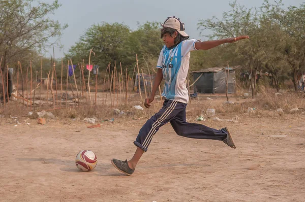 Chaco. Arjantin. 15-01-2019. Kuzey Arjantin 'in Chaco Eyaleti' nde Arjantin takımı tişörtleriyle futbol oynayan yerli bir çocuk..