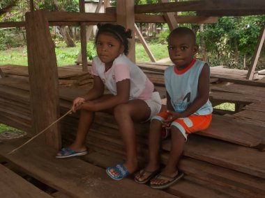 Darien Eyaleti, Panama. 07-18-2019. Orta Amerika, Panama 'daki Darien Vilayeti' nden yerli bir çocuk oturmuş kameraya bakıyor..