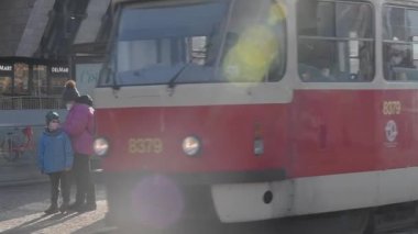 Prag, Çek Cumhuriyeti. 03-12-2021. Soğuk bir kış günü Prag şehir merkezindeki Hradcanska tramvay istasyonuna varmak için tramvayı bekleyen maskeli insanlar. 
