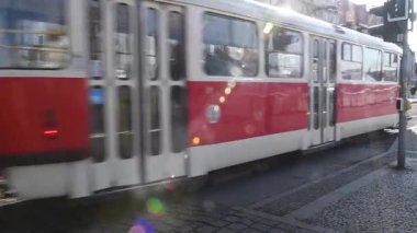 Prag, Çek Cumhuriyeti. 03-12-2021. Soğuk bir kış gününde Hradcanska istasyonunda tramvay raylarından maskeli insanlar geçiyor..