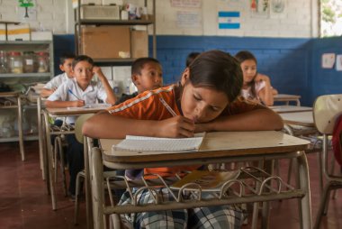 Suchitoto, El Salvador. 03-18-2019. Suchitoto 'nun eski kasabasındaki sınıfta yazan bir kızın portresi..