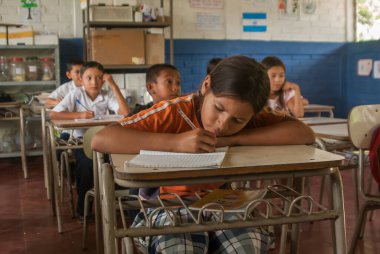 Suchitoto, El Salvador. 03-18-2019. Suchitoto 'nun eski kasabasındaki sınıfta yazan bir kızın portresi..