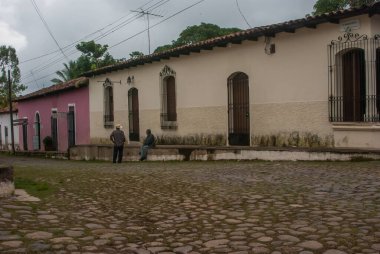 Suchitoto, El Salvador. 03-18-2019. Suchitoto 'da Cobble Caddesi' nde bir iş gününden sonra konuşan iki işçi..