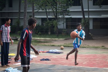 Varanasi, Hindistan. 10-16-2019. Bir grup genç erkek Varanasi 'deki okul binasında basket oynuyor..
