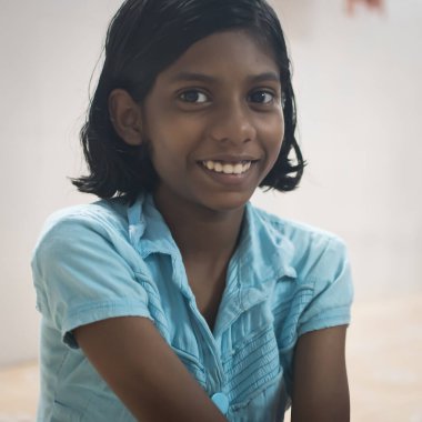 Varanasi, Hindistan. 10-16-2019. Varanasi 'de okul sırasında kameraya bakan gülümseyen bir kızın portresi..