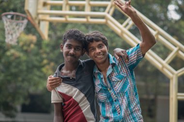 Varanasi, Hindistan. 10-14-2019. Yatılı okuldan iki genç erkek arkadaş futbol oynamayı bitirdikten sonra kameranın önünde poz veriyorlar..