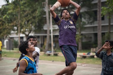 Varanasi, Hindistan. 10-14-2019. Bir grup ergen erkek öğle yemeğinden sonra okulda basketbol oynayarak eğleniyorlar..