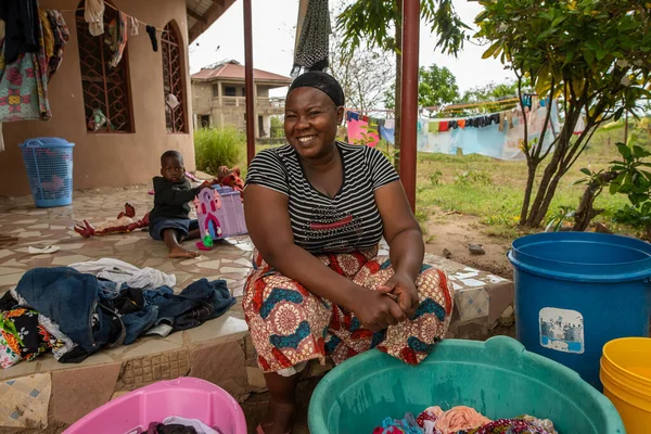坦桑尼亚多多玛08 2019 一位面带微笑的妇女正坐在椅子上 用肥皂和水捆扎着她的家人的衣服 — 图库照片