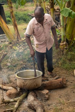 Dodoma, Tanzanya. 08-18-2019. Zenci bir adam Tanzanya 'nın kırsal kesimindeki okulda okuyan çocuklar için yemek pişiriyor..