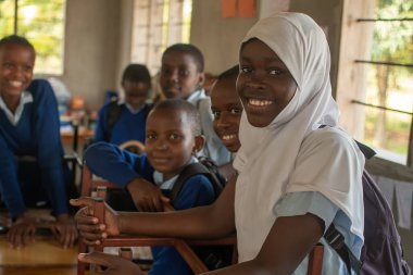 Dodoma, Tanzanya. 08-18-2019. Eşyalarını topladıktan sonra kameraya gülümseyen ve eve gitmeye hazır bir grup çocuğun portresi..