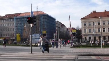 Prag, Çek Cumhuriyeti. 03-28-2021. İnsanlar güneşli bir günde Hradcanska tramvay istasyonunda tramvaya binmek için caddeyi geçiyorlar..