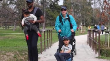 Prag, Çek Cumhuriyeti. 04-12-2021. İki çocuklu bir çift, Park Stromovka 'nın güzel manzarasında küçük bir köprüden geçiyorlar..