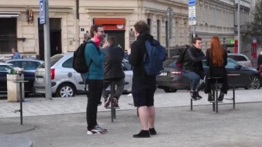 Prag, Çek Cumhuriyeti. 04-15-2021. Prag 6 'da küçük bir meydanda iki erkek arkadaş dondurma yerken Hradcanska tramvay istasyonunda eğleniyorlar..
