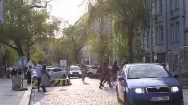 Prag, Çek Cumhuriyeti. 04-15-2021. Prag 'da Hradcanska' ya yakın bir kaldırım yolunda gün batımında güzel bir ışıkla insanların hareketi.