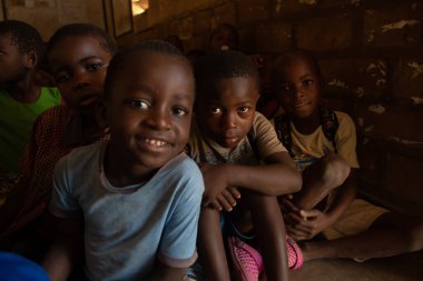 Mzuzu, Malawi. 30-05-2018. Gülümseyen bir çocuk ve diğer okul arkadaşları Malawi kırsalındaki derslere katılıyorlar..