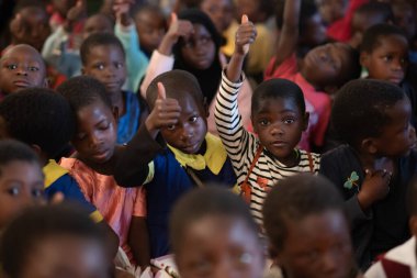Mzuzu, Malawi. 30-05-2018. Malavi 'de kırsal bir okulda okuyan Afro-soydan gelen çocuklar öğretmenlerini tebrik ediyorlar..