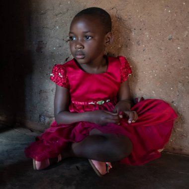 Mzuzu, Malawi. 30-05-2018. Malawi kırsalındaki bir köyde okulunda kırmızı elbiseli güzel bir zenci kızın portresi..