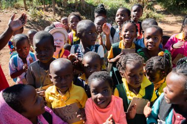 Mzuzu, Malawi. 30-05-2018. Bir grup siyah çocuk ve Malavi 'deki okullarının önünde kameraya gülümseyen bir albino..