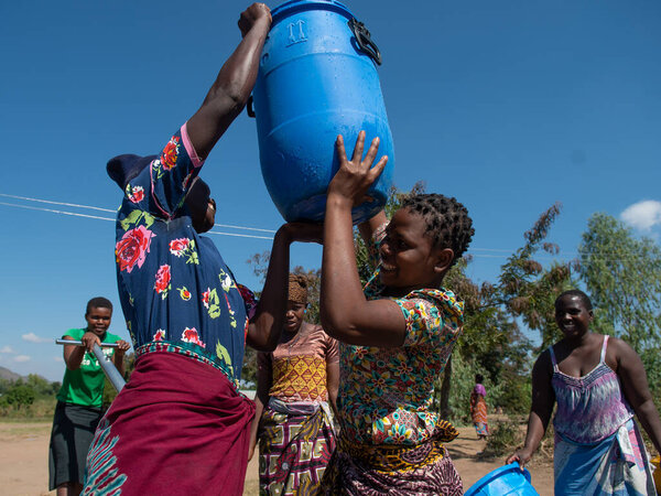 Mzuzu, Malawi. 30-05-2018. Mother and children from the community are gathered to fetch drinkable water for drinking and cooking in Malawi.