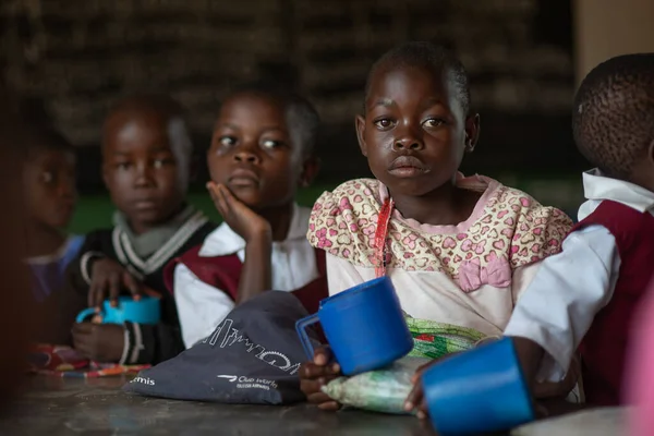 Mzuzu, Malawi. 30-05-2018. Malawi 'deki kırsal bir okulda ders aralarında yemek yiyen siyah kızların portresi..