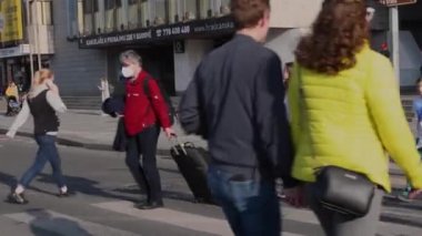 Prag, Çek Cumhuriyeti. 04-15-2021. Aralarında bavullu bir gezginin de bulunduğu bir grup insan Prag 'daki Hradcanska istasyonundan geçmek için ışığın yeşile dönmesini bekliyor..