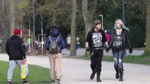 チェコ共和国プラハ 2021年 ハードメタルの黒い布 黒いブーツ 長い塗装の髪とプラハの春の公園ストロフカのハードロックバンドのTシャツを身に着けている若いカップル — ストック動画