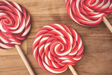 Ahşap arka planda kırmızı ve beyaz kıvrımlı Noel lolipopları. Noel arkaplanı.