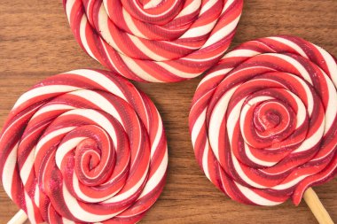 Ahşap arka planda kırmızı ve beyaz kıvrımlı Noel lolipopları. Noel arkaplanı.