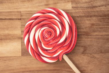 Ahşap arka planda kırmızı ve beyaz kıvrımlı Noel lolipopları. Noel arkaplanı.