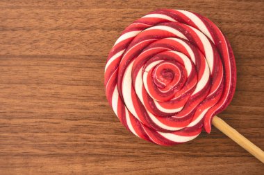 Ahşap arka planda kırmızı ve beyaz kıvrımlı Noel lolipopları. Noel arkaplanı.