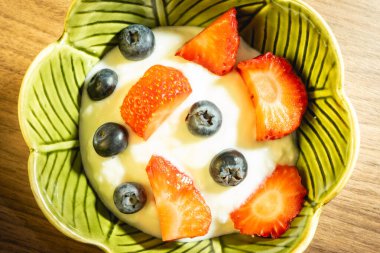 Çilek ve yabanmersinli yeşil bir kase yoğurt. Sağlıklı yemek..