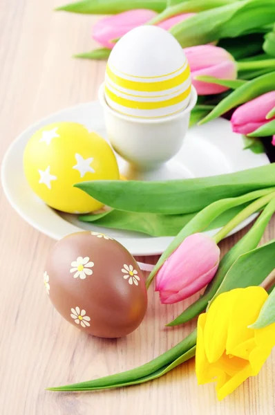 Œuf de Pâques en tasse avec un bouquet de tulipes autour — Photo