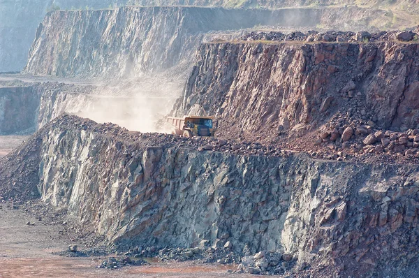 Dumper truck driving through a quarry mine. excavator in backgro — Stock Photo, Image